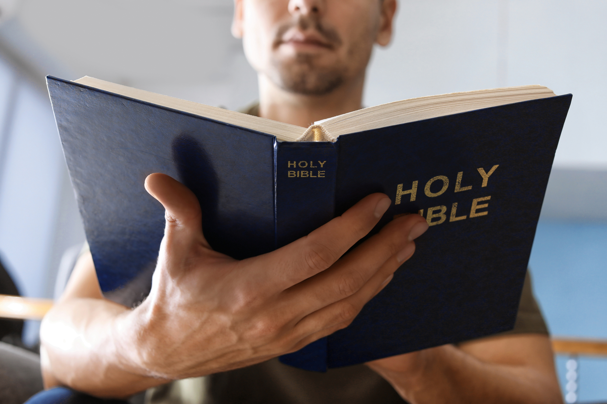 man holding an open bible - Abiding Savior Evangelical Lutheran Church of Elk River, MN